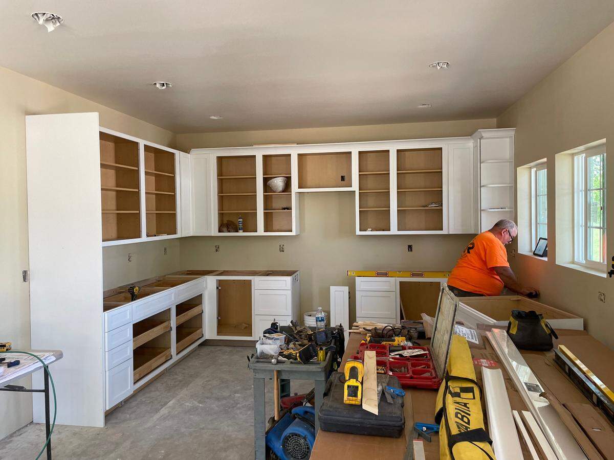 Builder from Red River Construction works on cabinets in the kitchen of Burt and Aurora Skurtun’s ADU in Patterson on Friday, April 19, 2024.