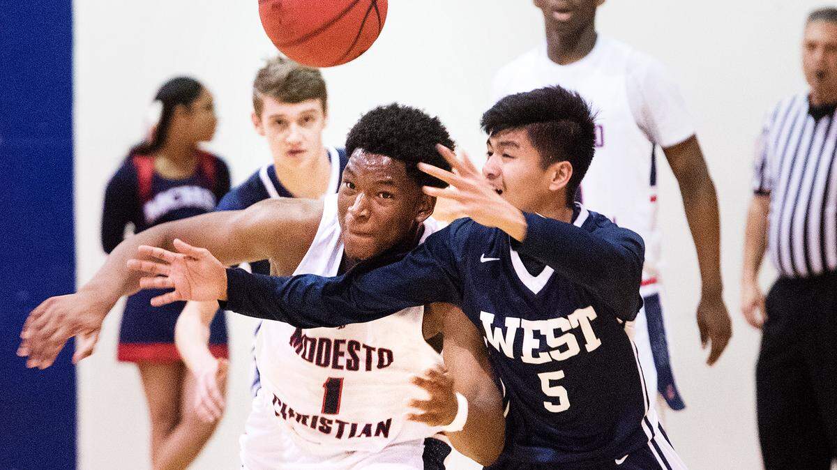Modesto Christian’s Prince Adza battles for the ball with West’s JP Patague during Tri-City Athletic League game in Salida, Calif., Thursday, Jan. 24, 2019.