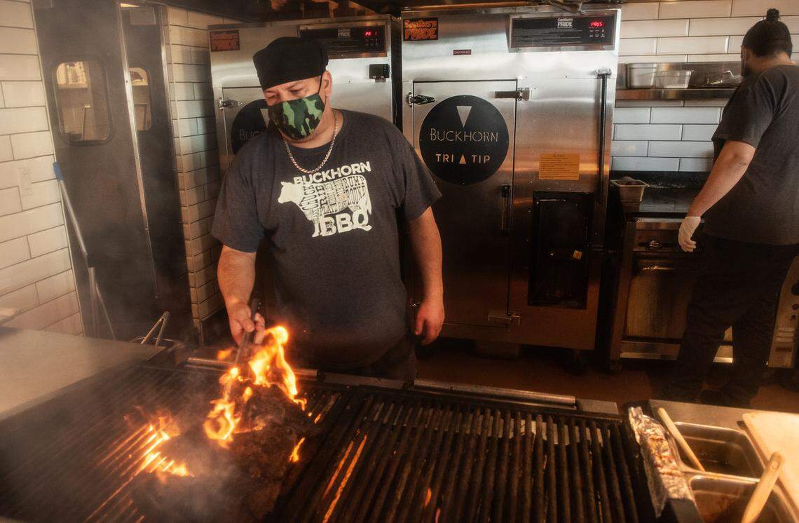 Cook Ruben Carmona grills tri-tip at Buckhorn BBQ at Vintage Faire Mall in Modesto, Calif., on Thursday, Dec. 3, 2020.
