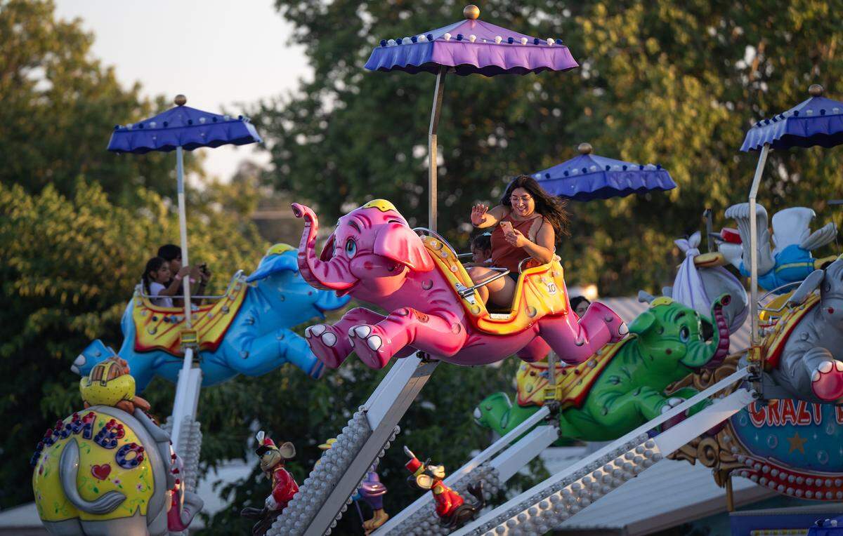 Visitors ride Crazy Dumbo in the midway at the Stanislaus County Fair in Turlock, Monday, July 14, 2025. 