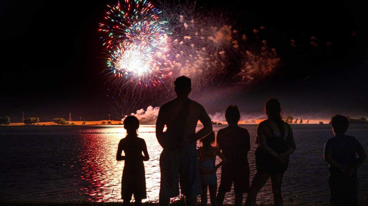 A family watches the Independence Day fireworks celebration at Woodward Reservoir in 2023.