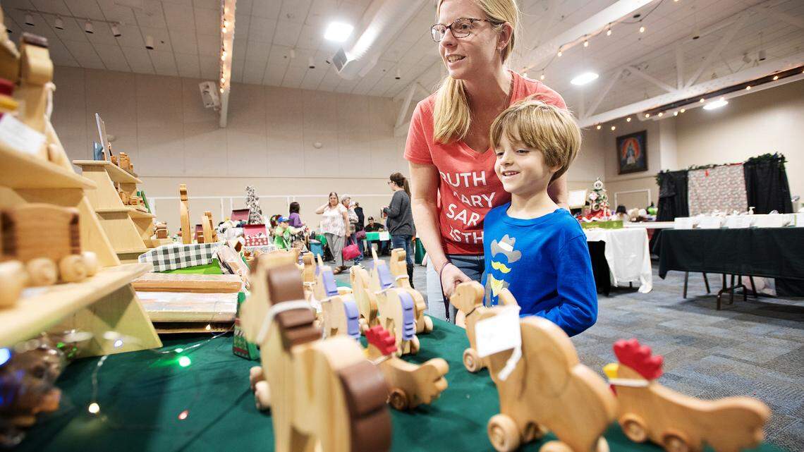 Lauren Moraca and her son Daniel, 6, look at wooden toys made by Maureen Galasco during the Valley’s Finest Craft and Goods Fair at St. Joseph’s Catholic Church’s Father O’Hare Hall in Modesto, Calif., Saturday, Nov. 17, 2018. 