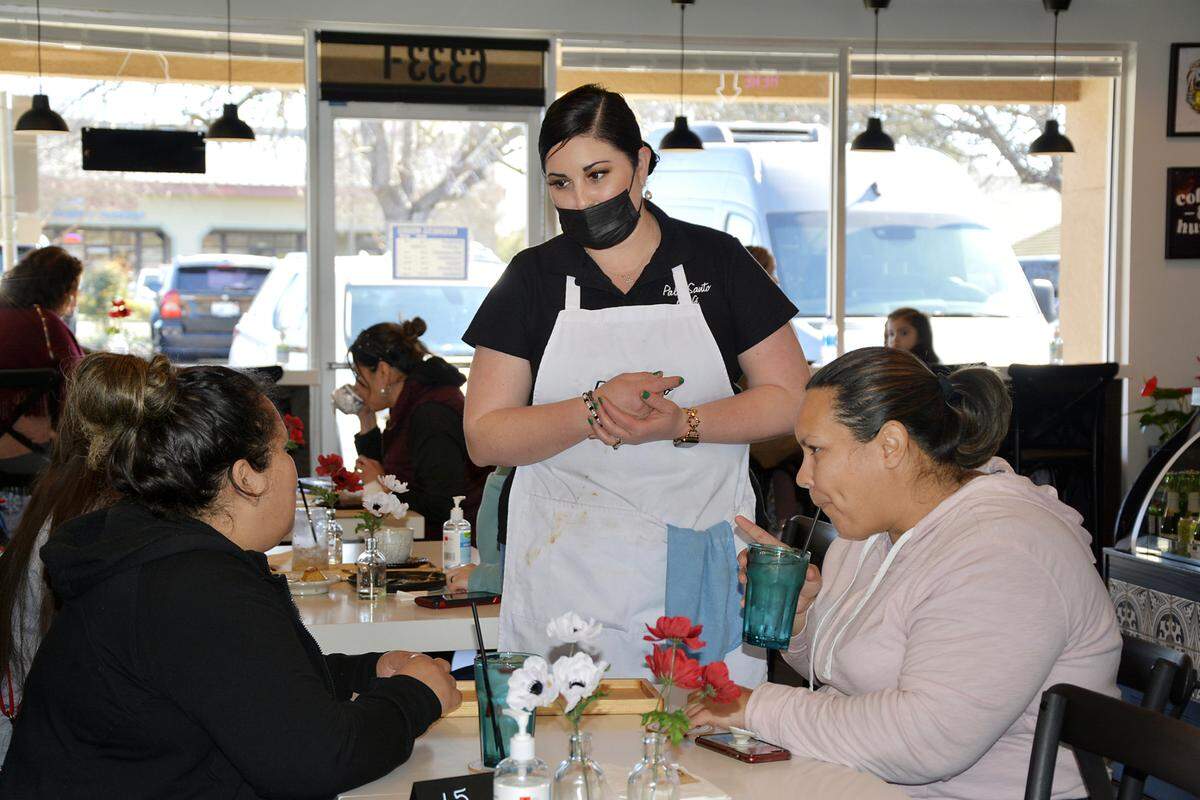 Palo Santo Cafe owner Nayeli Vazquez speaks with customers at her new Riverbank eatery in Riverbank, Calif. Feb. 23, 2021.