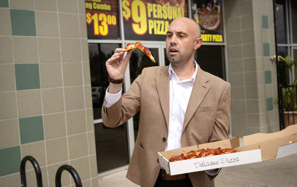 Reviewer Damien Wilson observes the “flop” of a slice of pepperoni pizza at Rico’s Pizza in Turlock, Thursday, March 27, 2025.