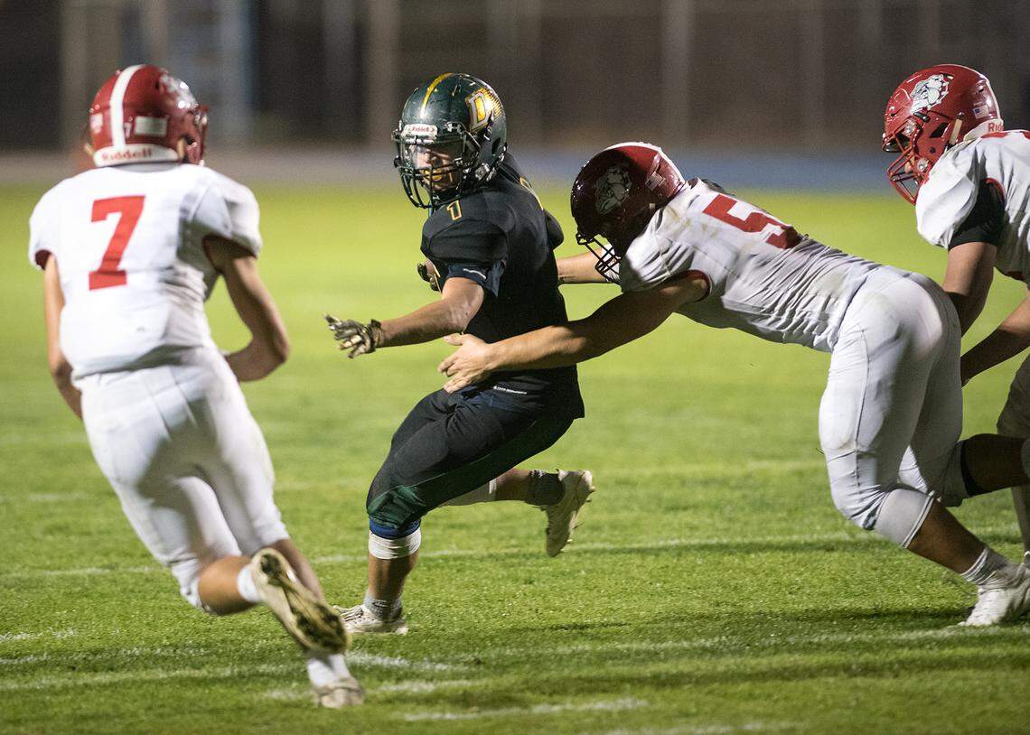 Davis’ Francisco Mercado runs the ball as Ceres defenders close the gap during the Western Athletic Conference game at Modesto Junior College  in Modesto, Ca., on Thursday, Oct. 25, 2018. Davis won the game 42-7.