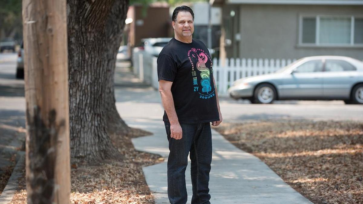 Chris Goodrum still wears a splint and has trouble walking after breaking his ankle, he seen at the site of the accident in Modesto Calif., Saturday, July 28, 2018. Modesto has paid $250,000 to settle a lawsuit that said the city was at fault for Goodrum, tripping, falling and severely breaking his ankle on a defective city sidewalk on East Morris Avenue while walking one of his dogs at night.