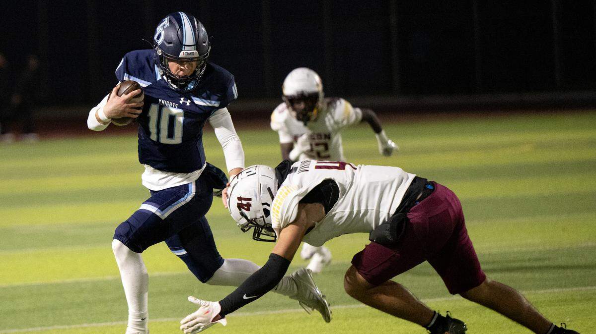 Downey quarterback Carson Lamb escapes a tackle from Edison’s Ramon Manning during the Sac-Joaquin Section D1 playoff game at Downey High School in Modesto, Friday, Nov. 8, 2024.
