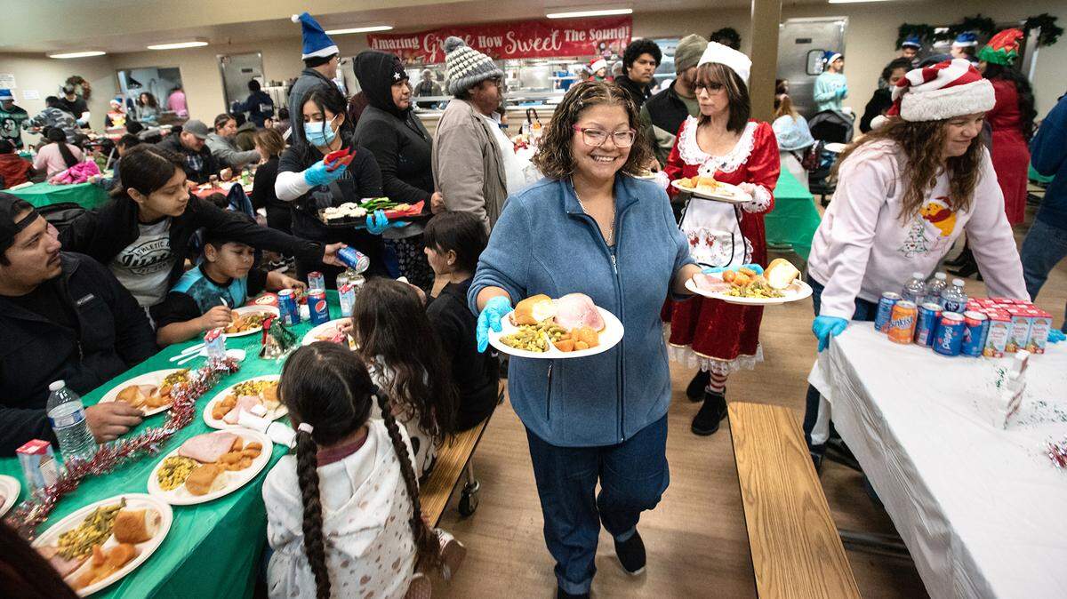 Volunteer Maggie Vasquez delivers hot holiday meals during Modesto Gospel Mission’s annual Christmas gathering in Modesto, Calif., Friday, Dec. 23, 2022.