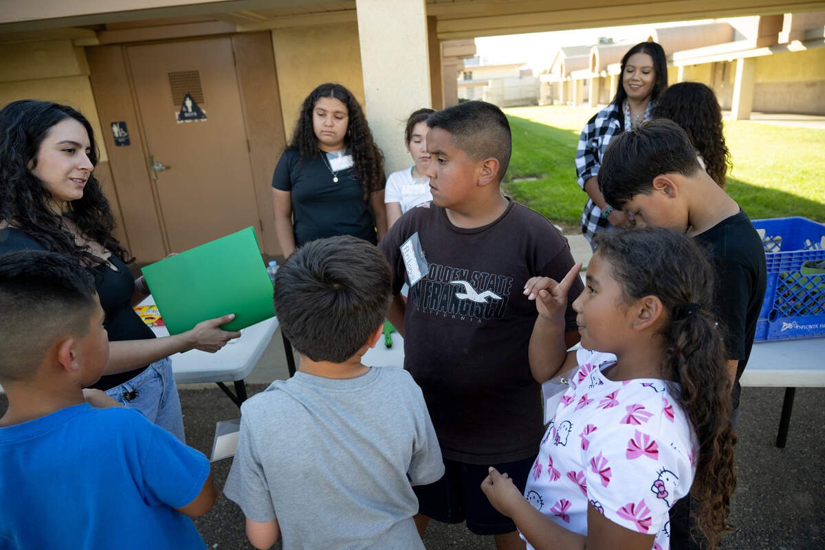 Meriam Jacobs, education programs manager at East Stanislaus Resource Conservation District, left, talks with Nathalie Cervantes, right, Antonio Paez, middle, and other students about documenting the growth of the vegetable garden as part of the Junior Farmer program at Empire Elementary School in Empire, Friday, Oct. 4, 2024.