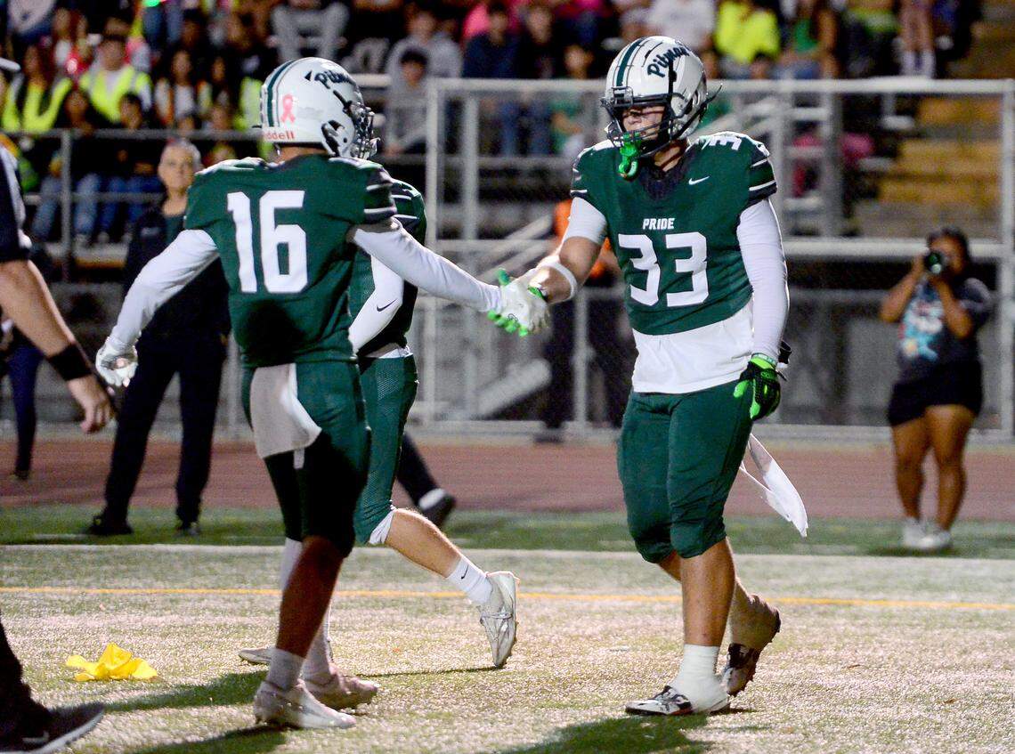 Pitman receiver Jayden Machado (33) and Caleb Grossman (16) celebrate after Machado scored a touchdown during the game with Modesto at Turlock High School in Turlock, Oct. 3, 2025.