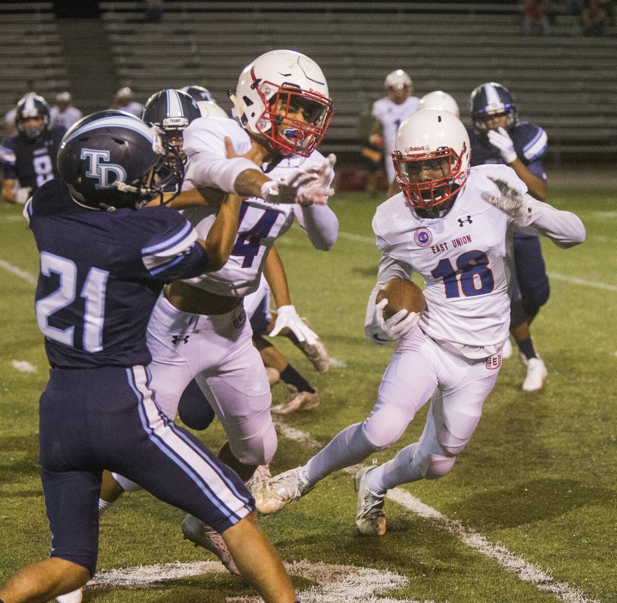 Tealen Gaines, 18, of East Union tries to get around Downey Highs, Christian Diaz, 21, with the help of Nicco Cedolini, 14, of East Union.  Downey High took on East Union Friday Aug. 17, 2018.