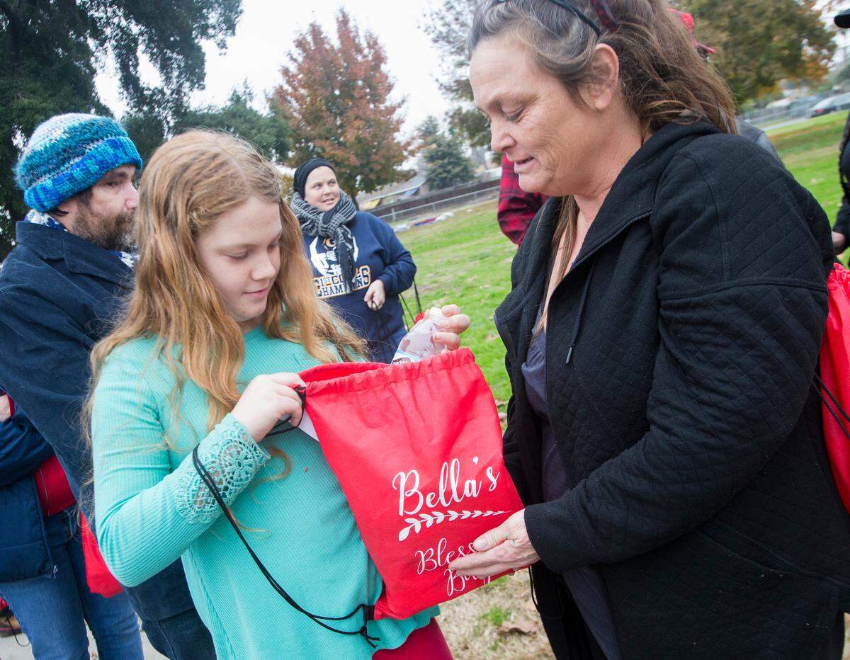 Debbie Ohm, right, and Emily Potts look through their Bella Bag they received from Melissa and Josh Regacho Sunday Dec. 9, 2018 at Oregon Park. Melissa and Josh opend the morning handing out Bella Bags in honor of their daughter that passed away from meningitis in 1999.