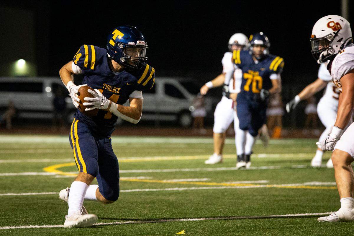 Turlock High receiver Carter Crivelli (14) works his way upfield after catching a 10-yard pass during the first half of Friday night’s game against Clovis West.