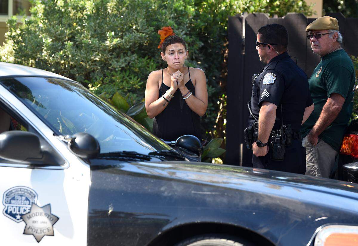 Kimberly Valente speaks with law enforcement on Monday afternoon Sept. 24, 2018 outside her home on Poinsettia Drive in Modesto, Calif.