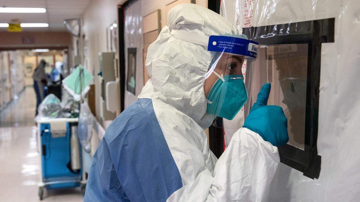 Nurse Summer Elmore checks on a patient through the door in the COVID unit at Central Valley Specialty Hospital in Modesto, Calif., on Tuesday August 18, 2020.