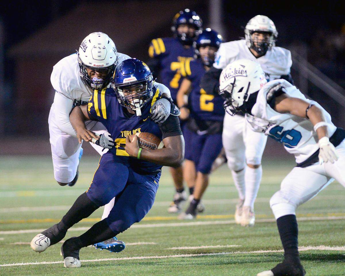 Turlock running back Tarell Johnson (24), cuts up field with a Sheldon defender on his back during a CIF Sac-Joaquin Section Football Division I playoffs game between Turlock High School and Sheldon High School at Turlock High School in Turlock, California on Nov. 3, 2023.