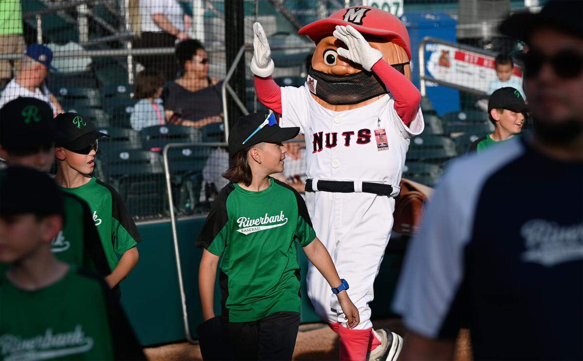 Youth baseball team members from Riverbank parade on the field before the opening day game between the Modesto Nuts and the San Jose Giants at John Thurman Field in Modesto, Calif., on Friday, April 8, 2022. Modesto won the game 5-3.