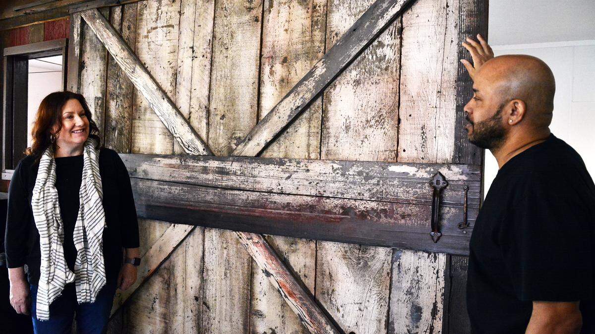 Trace Tedde-Vega (left) and William Ross stand in front of a vintage barn door they’ve had installed in their new restaurant Southern Magnolia Kitchen, in the former Farmer’s Catfish House building on Feb. 29, 2020 just west of Modesto, Calif.