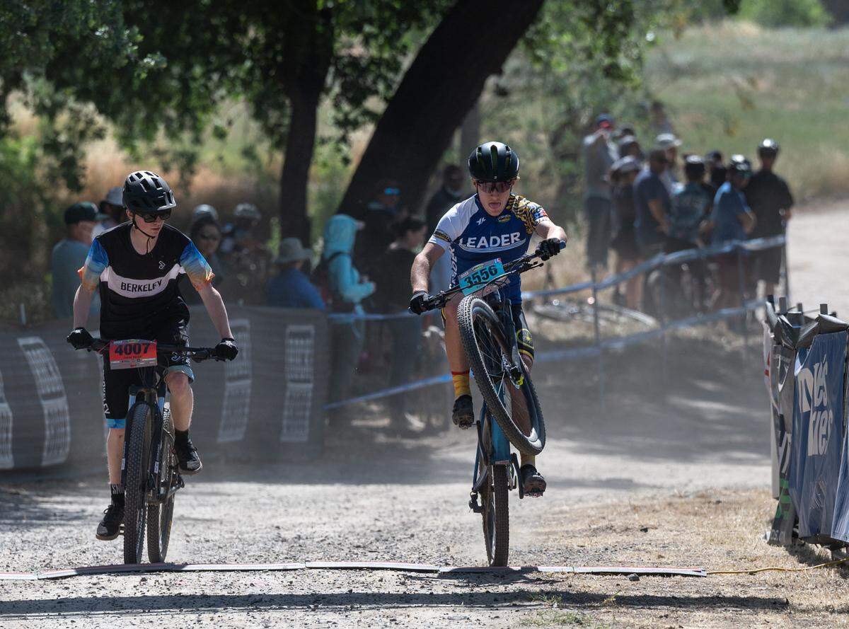 Sophomore Ryder Ritchie of Monterey, right, crosses the finish line with a time of 35:58.13 for the win in the boys division II 10-mile race at Tuolumne River Regional Park during the NorCal Interscholastic Cycling League event in Modesto, Calif., on Saturday, April 9, 2022.