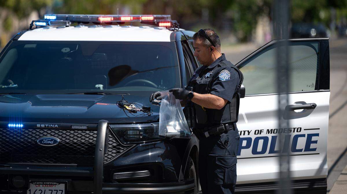 A Modesto Police officer bags up a suspects belongings during an arrest in Modesto, Calif., on Tuesday, April 12, 2022.