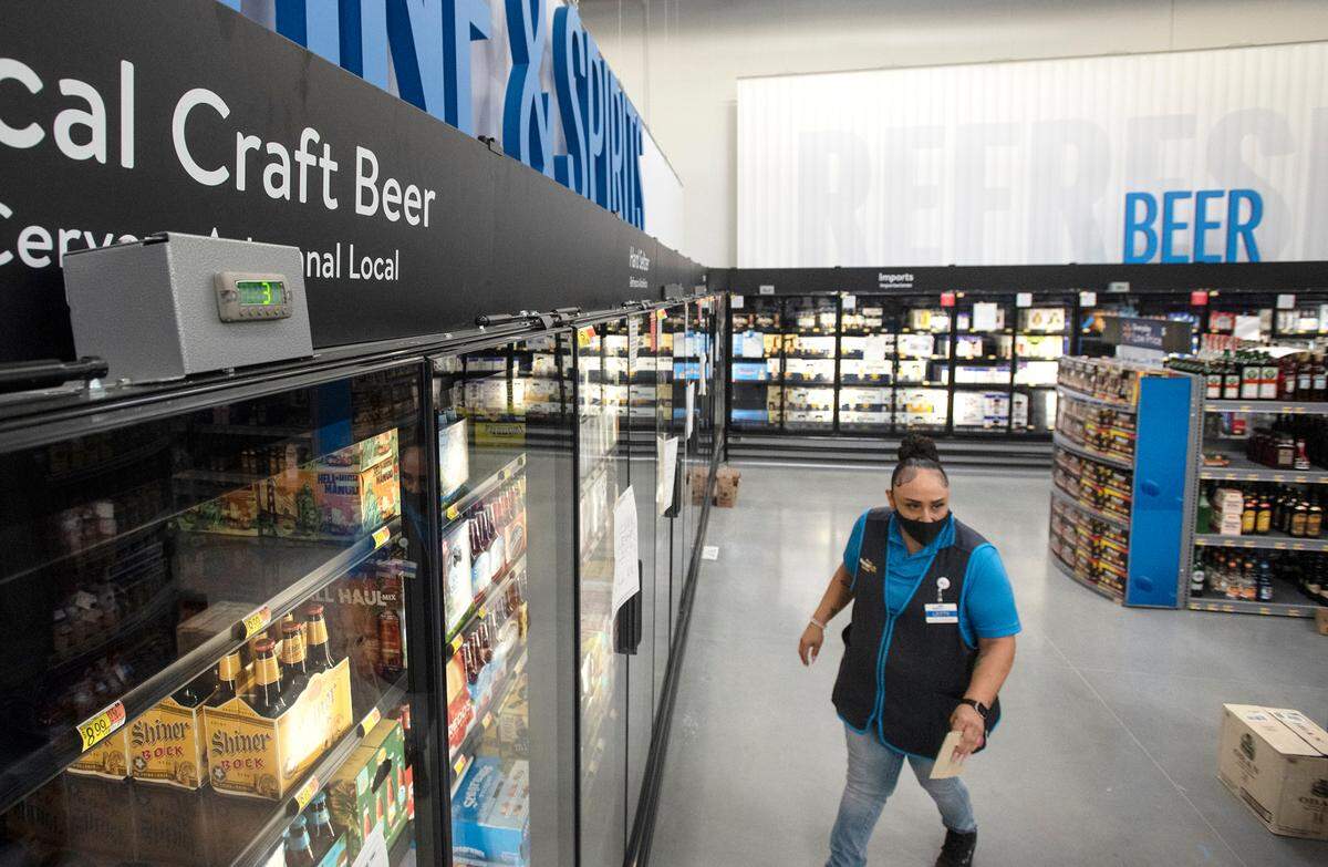 Letty Ochoa helps prepare the liquor department at the Walmart Supercenter in Ceres ,Calif., on Wednesday, Nov. 17, 2021.