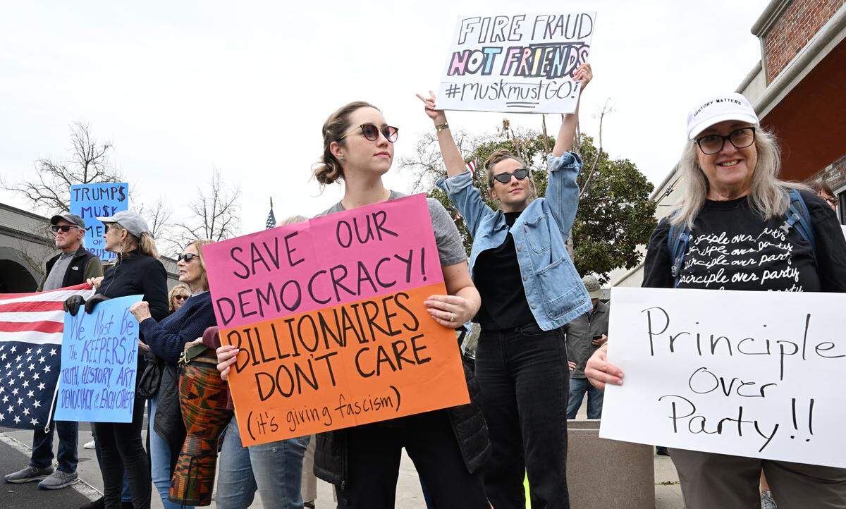 Protesters call out to motorists on J Street to protest Trump administration policies in Modesto, Monday, Feb. 24, 2025.