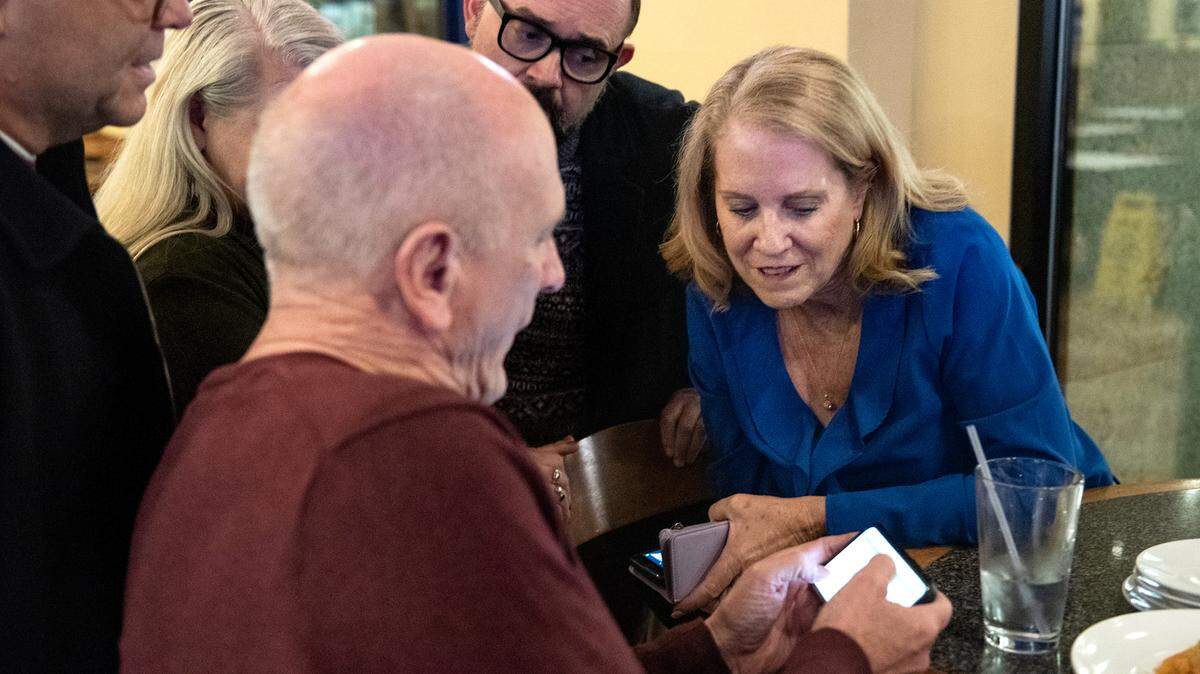 Modesto City Schools Superintendent Sara Noguchi, right, and board member Chad Brown, left, look at early results for Measure L with other supporters at Fuzio restaurant in Modesto Calif., on Election Night, Tuesday, Nov. 8, 2022.