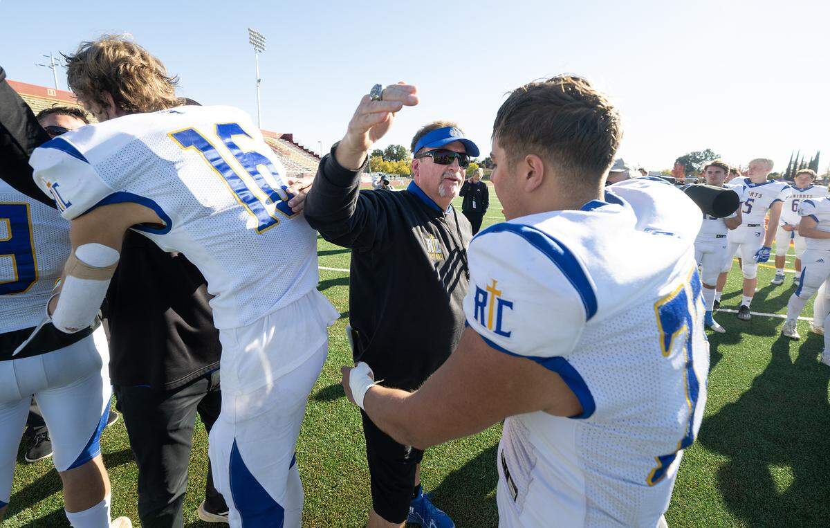 Ripon Christian coaches, including head coach Phil Grams hug the seniors, including Connor Deshields (77) after the Knights loss to Woodland Christian in the Sac-Joaquin Section Division VII NorCal Qualifier at Sacramento City College in Sacramento, Calif., Saturday, Nov. 25, 2023.