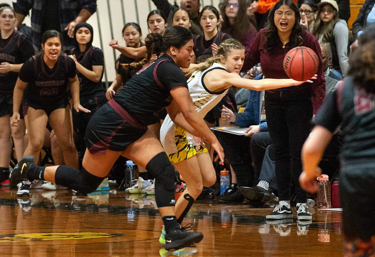 Hughson’s Raegan Barstow and Riverbank’s Rayne Tago chase after a loose ball during the Trans Valley League game in Hughson, Calif., Tuesday, Jan. 31, 2023.