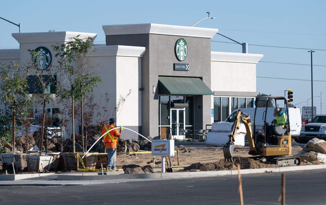 Landscapers work next to the Starbucks Coffee at Ceres Gateway Center in Ceres, Calif., Thursday, Oct. 27, 2022.