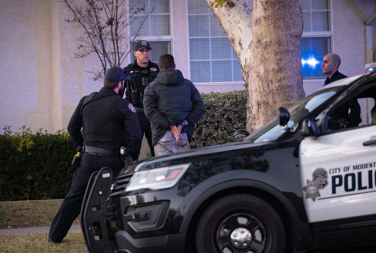 Modesto Police officers question a man after small fire was reported in Modesto, Calif., Tuesday, Nov. 22, 2022.