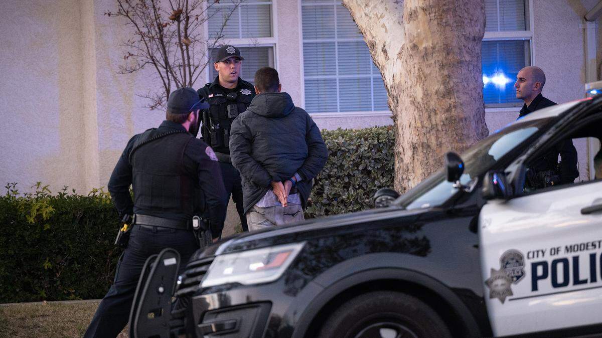 Modesto Police officers question a man after small fire was reported in Modesto, Calif., Tuesday, Nov. 22, 2022.