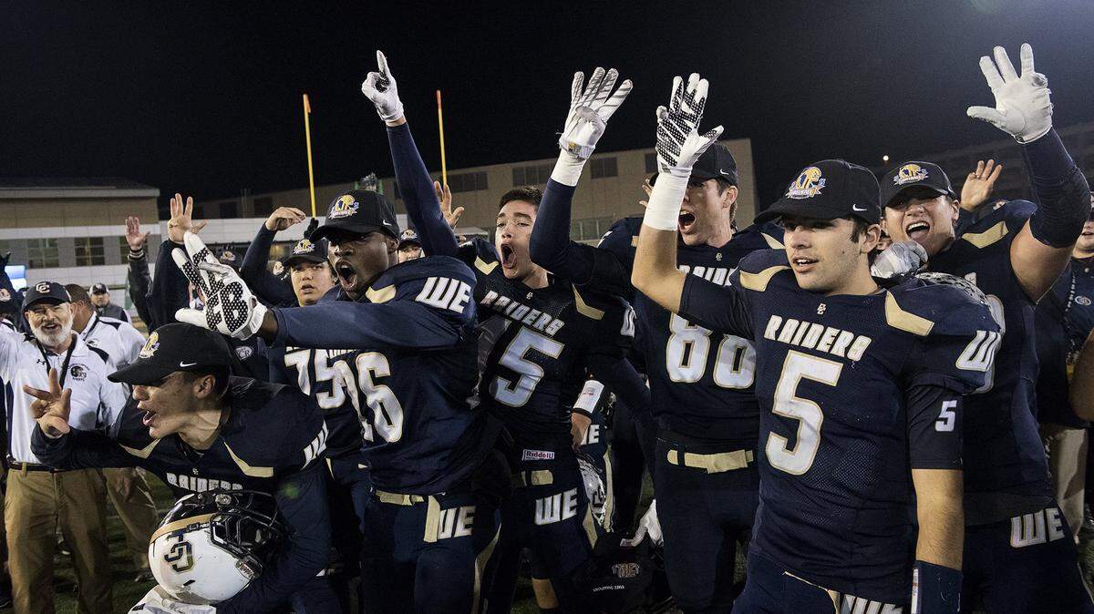 Central Catholic players hold up four fingers as they celebrate their fourth consecutive state championship after the CIF Open Division Small School championship with San Marino at California State University, Sacramento on Dec. 19, 2015.
