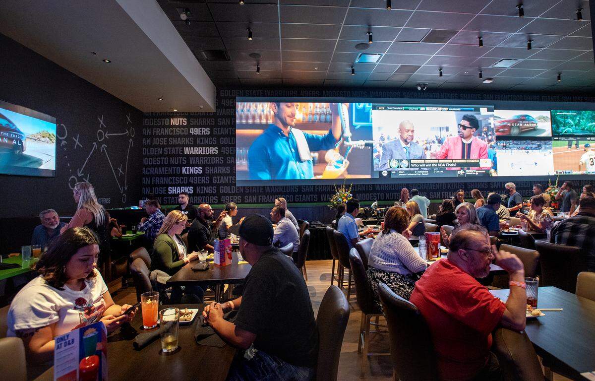 Guests enjoy a VIP buffet and the 40-foot “WOW Wall” inside the sports bar at Dave & Buster’s entertainment center and restaurant at Vintage Faire Mall in Modesto, Calif., on Thursday, June 2, 2022.