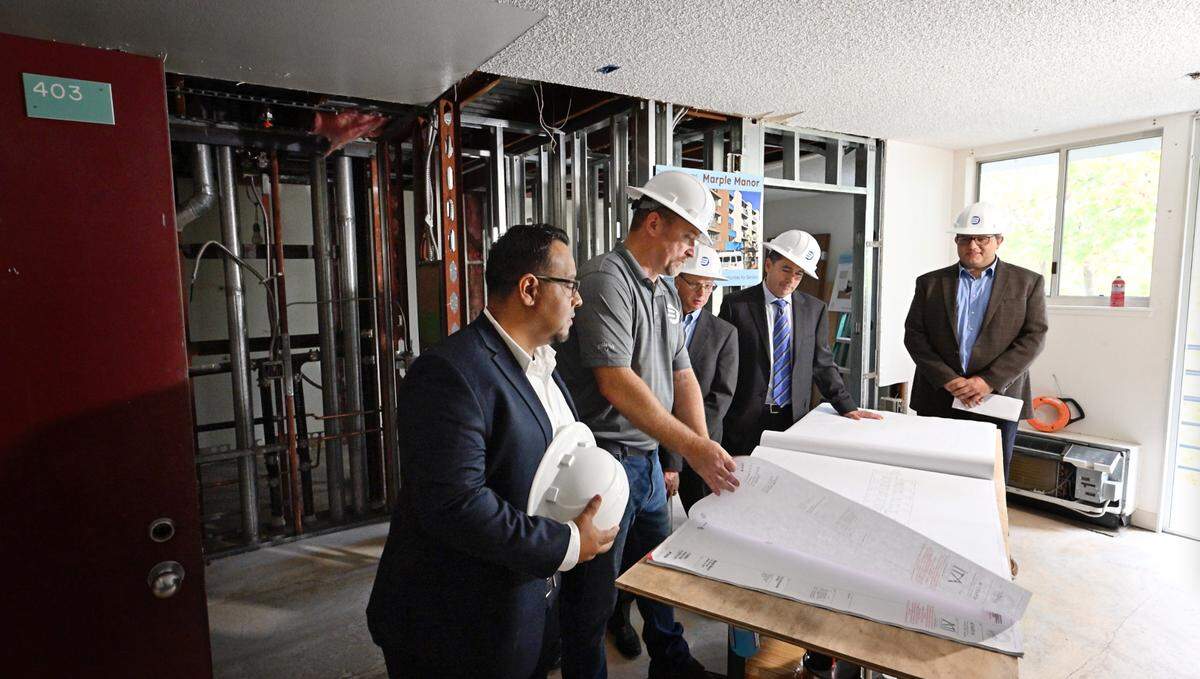 Officials look over plans in a fourth-floor apartment being renovated at Marple Manor senior housing complex in Modesto, Calif., Friday, Nov. 17, 2023. The $17.25 million project is scheduled to be completed by 2025.