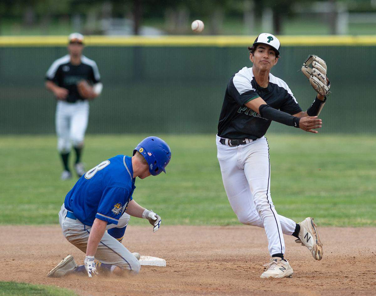 Pitman shortstop Christian Jacinto forces out Turlock’s Dustin Newsome at second and throws to first on a double play attempt during the Central California Athletic League game at Pitman High School in Turlock, Calif., on Thursday, April 14, 2022. The Turlock batter was safe.