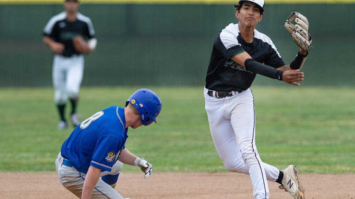 Pitman shortstop Christian Jacinto forces out Turlock’s Dustin Newsome at second and throws to first on a double play attempt during the Central California Athletic League game at Pitman High School in Turlock, Calif., on Thursday, April 14, 2022. The Turlock batter was safe.