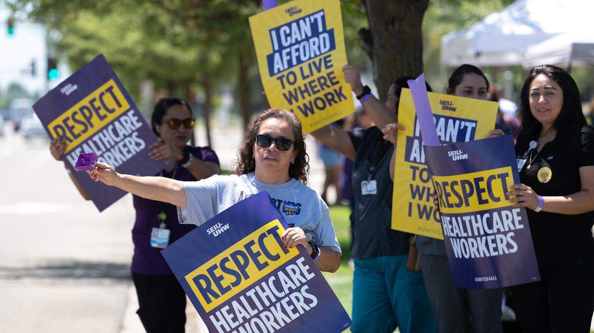 La trabajadora de Kaiser Leticia Andrade, en el centro, se manifiesta con otros empleados por la escasez de personal y los salarios en Modesto, California, el jueves 27 de julio de 2023. Los trabajadores de salud de primera línea de las instalaciones de Kaiser Permanente en la región están realizando manifestaciones en Modesto y en docenas de otras instalaciones en todo el estado, mientras continúan las negociaciones para un nuevo contrato laboral.