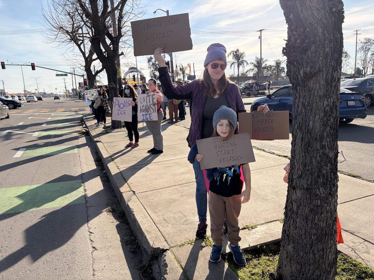 Kelly Gepley, of Modesto, and one of her sons hold up signs at the anti-ICE rally at the intersection of Hatch and Crows Landing roads in south Modesto on Saturday, Jan. 10, 2026.