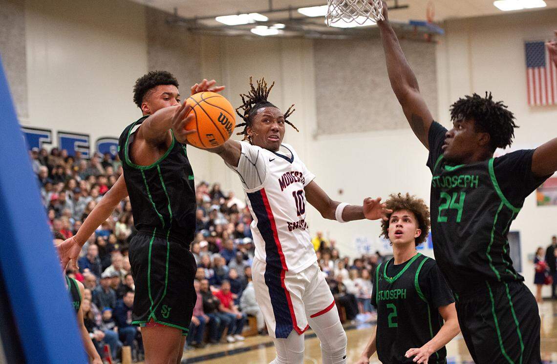 Modesto Christian’s BJ Davis challenges St. Joseph’s Caedin Hamilton and Tounde Yessoufou, right, during the NorCal Open Division championship game at Modesto Junior College in Modesto, Calif., Tuesday, March 7, 2023.