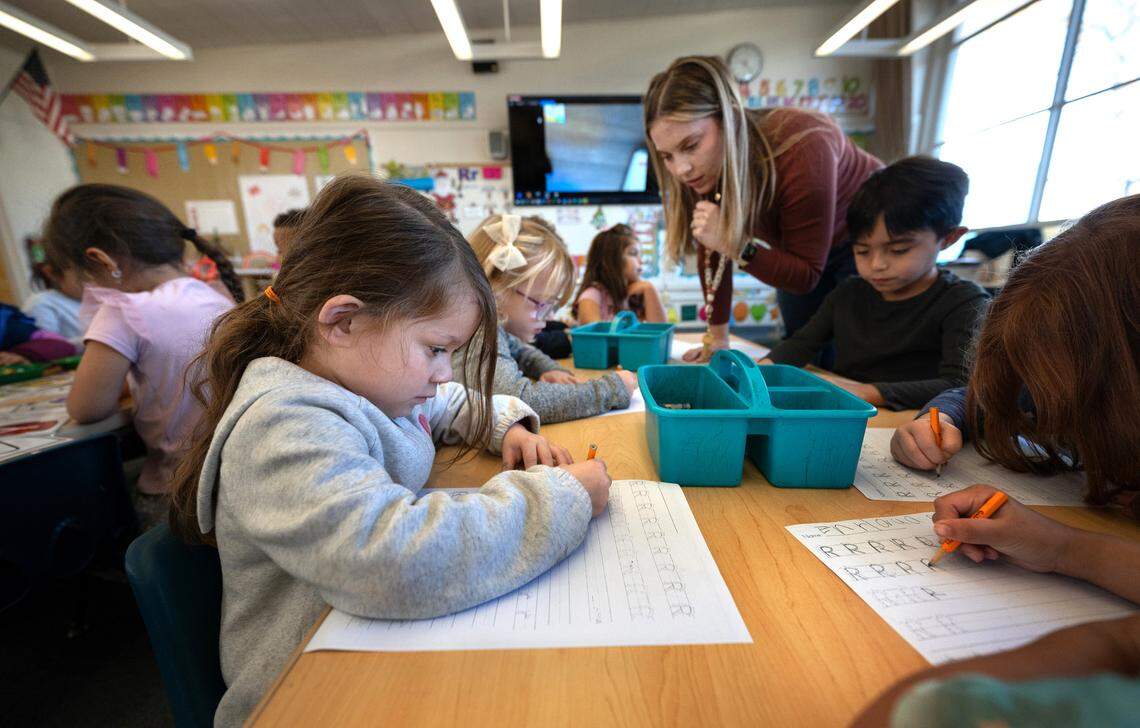 Transitional kindergarten student Vivienne Villarreal, left, and her classmates practice handwriting at Fremont School in Modesto , Calif., Thursday, Dec. 7, 2023. The kindergarten students are working on motors skills and letter recognition to prepare them for cursive writing in later grades. In October, Gov. Gavin Newsom signed a law requiring cursive handwriting instruction mandatory in first through sixth grades effective Jan. 1.