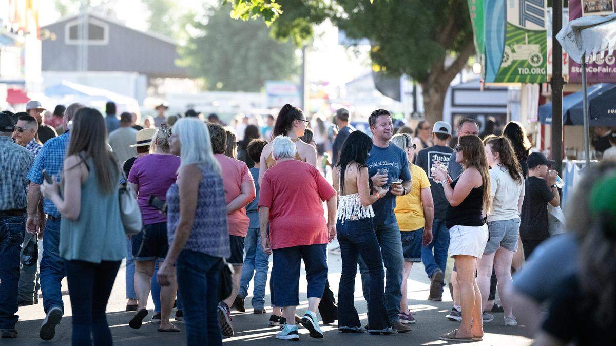 Fair visitors eat and drink at the Stanislaus County Fair in Turlock, Calif., Friday, July 7, 2023. The 2024 fair begins July 5, during a time the county is in the grip of a triple-digit heat wave.