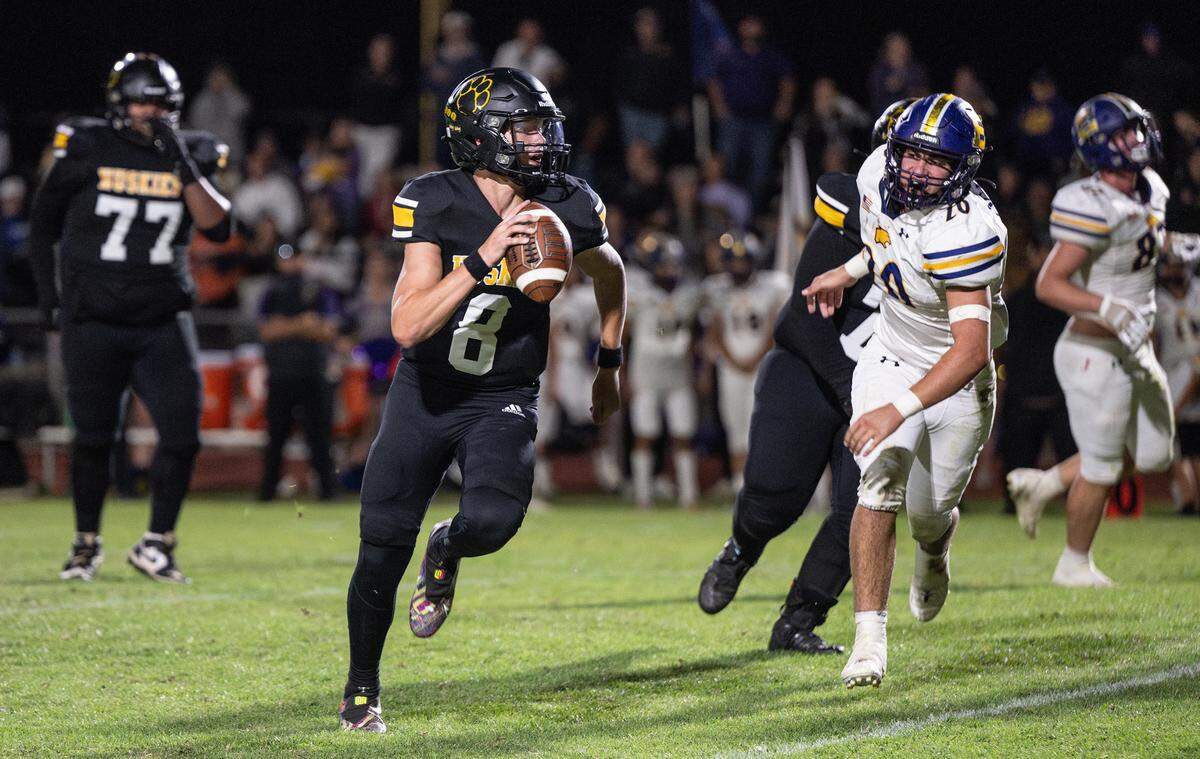 Hughson quarterback Robert McDaniel runs the ball for a first down during the Trans Valley League game with Escalon at Hughson High School in Hughson, Calif., Friday, Sept. 29, 2023.