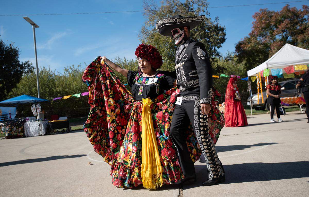 Catrina contest participants Anamaria Nava Cruz and Juan Arroyo dance during the Dia de los Muertos celebration at Fairview Park in Modesto, Calif., Saturday, Oct. 29, 2022.