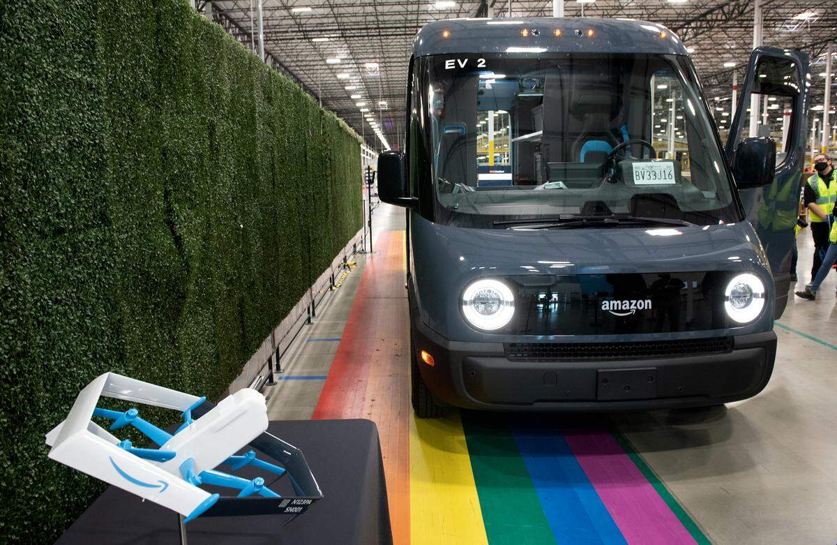 A small model of the larger drone that will begin delivering packages in Lockeford in December; also pictured is the new electric delivery van made by Rivian.