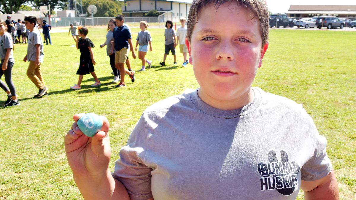 Fifth-grader Zack Shivar, 10, shows off his peace rock, which he painted to resemble a pearl. They share the same first three letters, he pointed out. Sept. 21, 2018. 