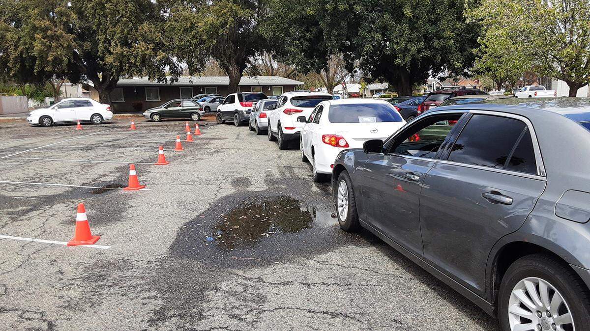 The drivers lined up Monday, March 15, 2021, outside The Gathering Covenant Church in Patterson, Calif., for groceries provided the chance for officials to tell them about the new rental assistance program.