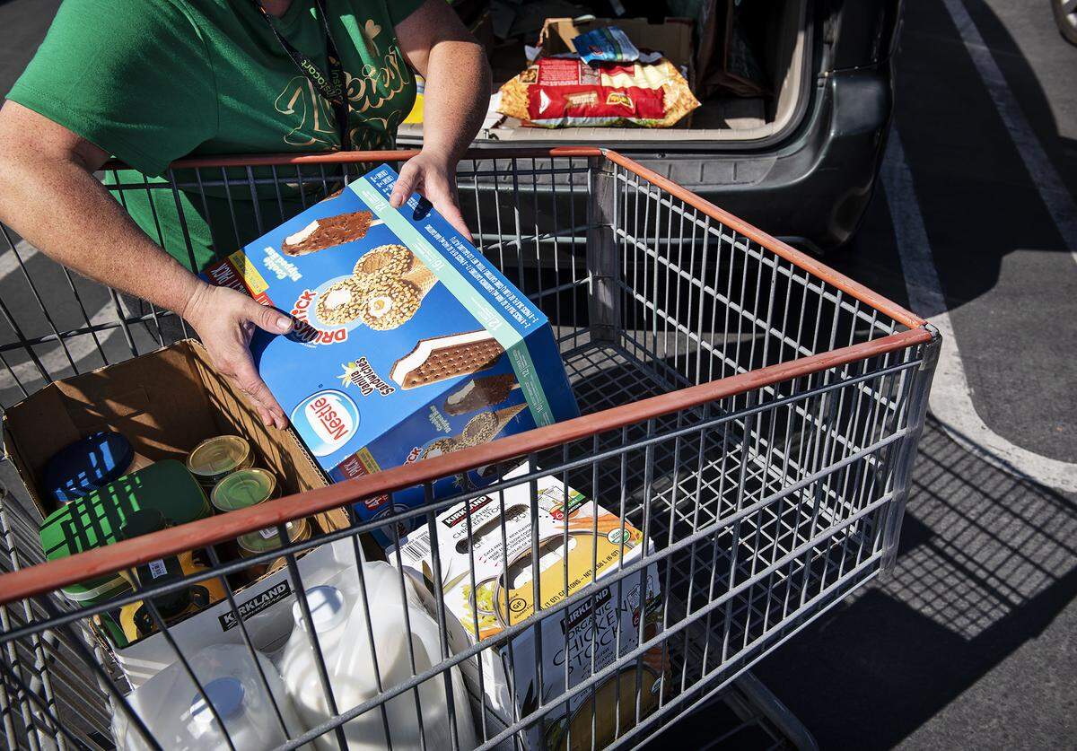 Andrea said she started working as a shopper for Instacart in December. She is loading her car after shopping for a client in Turlock, Calif., on Friday, March 27, 2020.  