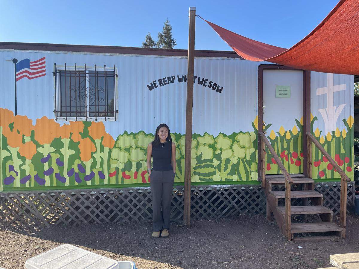 Eliana Gloria, at senior at Modesto High School, stands before the mural she painted at the Church of the Cross Community Garden in Modesto on Saturday, Oct. 4.