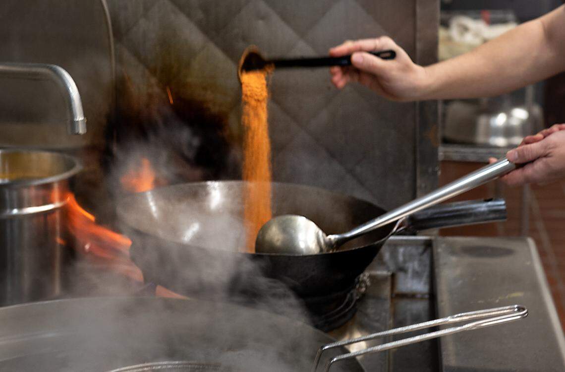 Owner Kevin Lin adds spices a seafood dish at Akitaca Crab seafood restaurant in Modesto, Calif., on Wednesday, March 16, 2022.